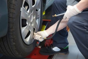 Auto Service Technician Checking Tire Pressure