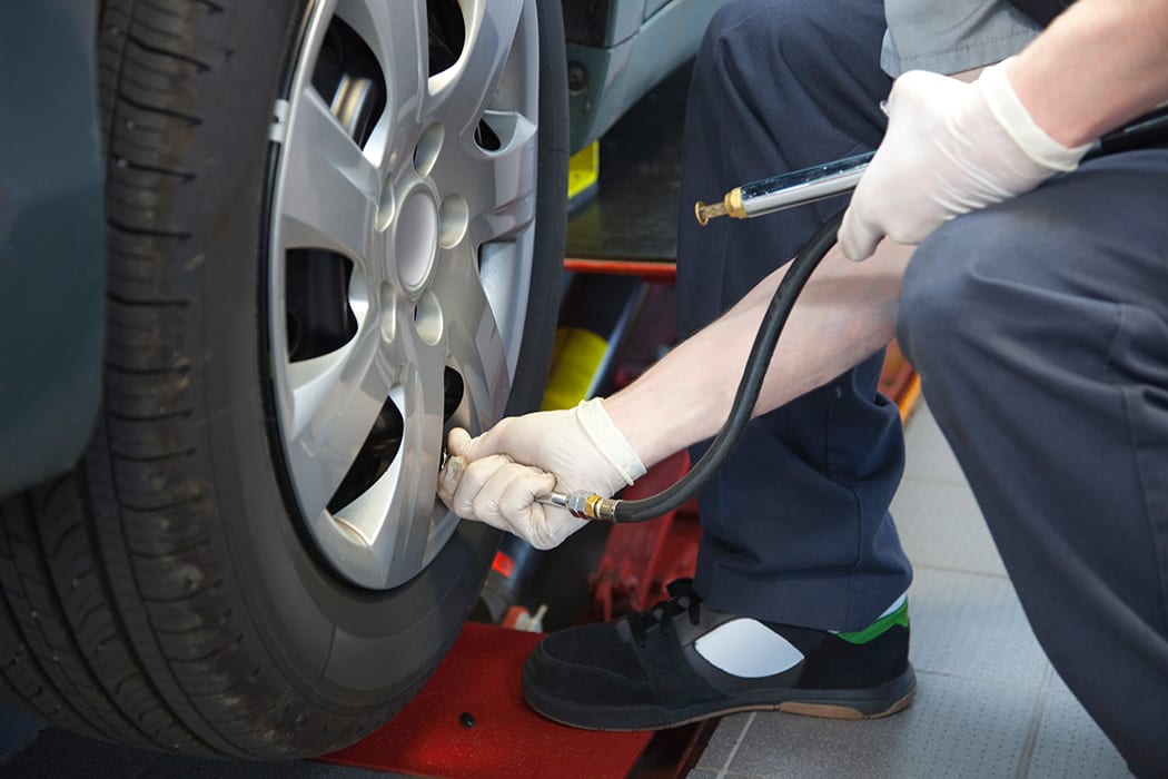 Auto Service Technician Checking Tire Pressure